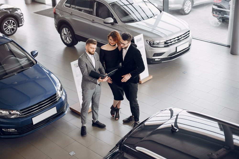 a sales person goes over paperwork with customers in a showroom